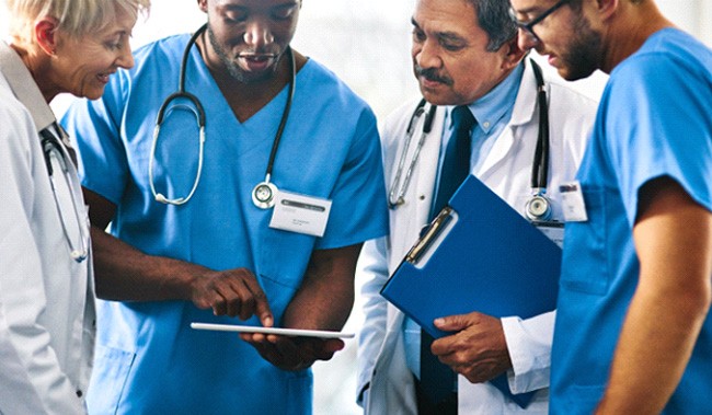 a team of medical professionals looking at a patient’s chart