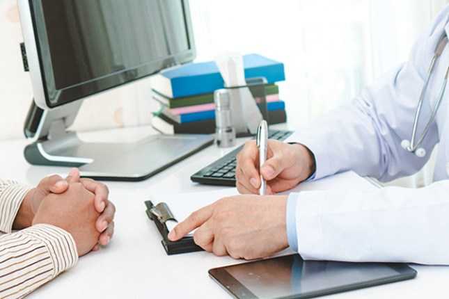 a doctor writing a referral form for a patient