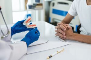 Patient and oral surgeon sitting at desk during consultation